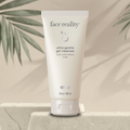 Tube of 'face reality' ultra gentle gel cleanser on a neutral background with green leaves and a stone surface.